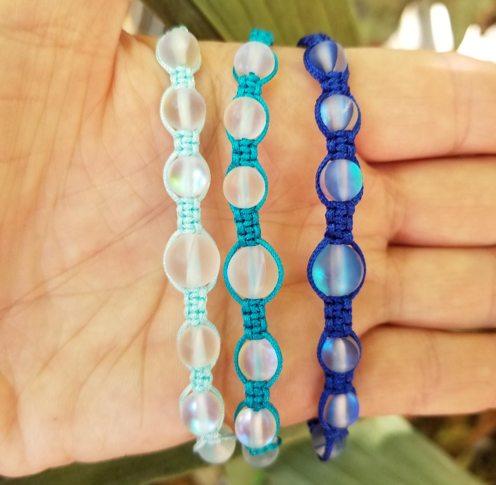 White glass beads with light blue, teal and dark blue cord bracelets