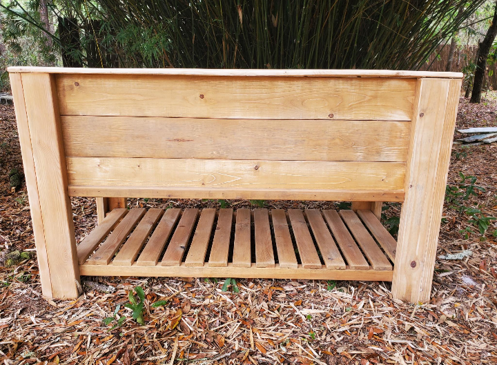 Raised Garden Boxes made of timber with a large trough and slatted shelf, ideal for spring planting, shown outdoors on wood chips with bamboo backdrop.