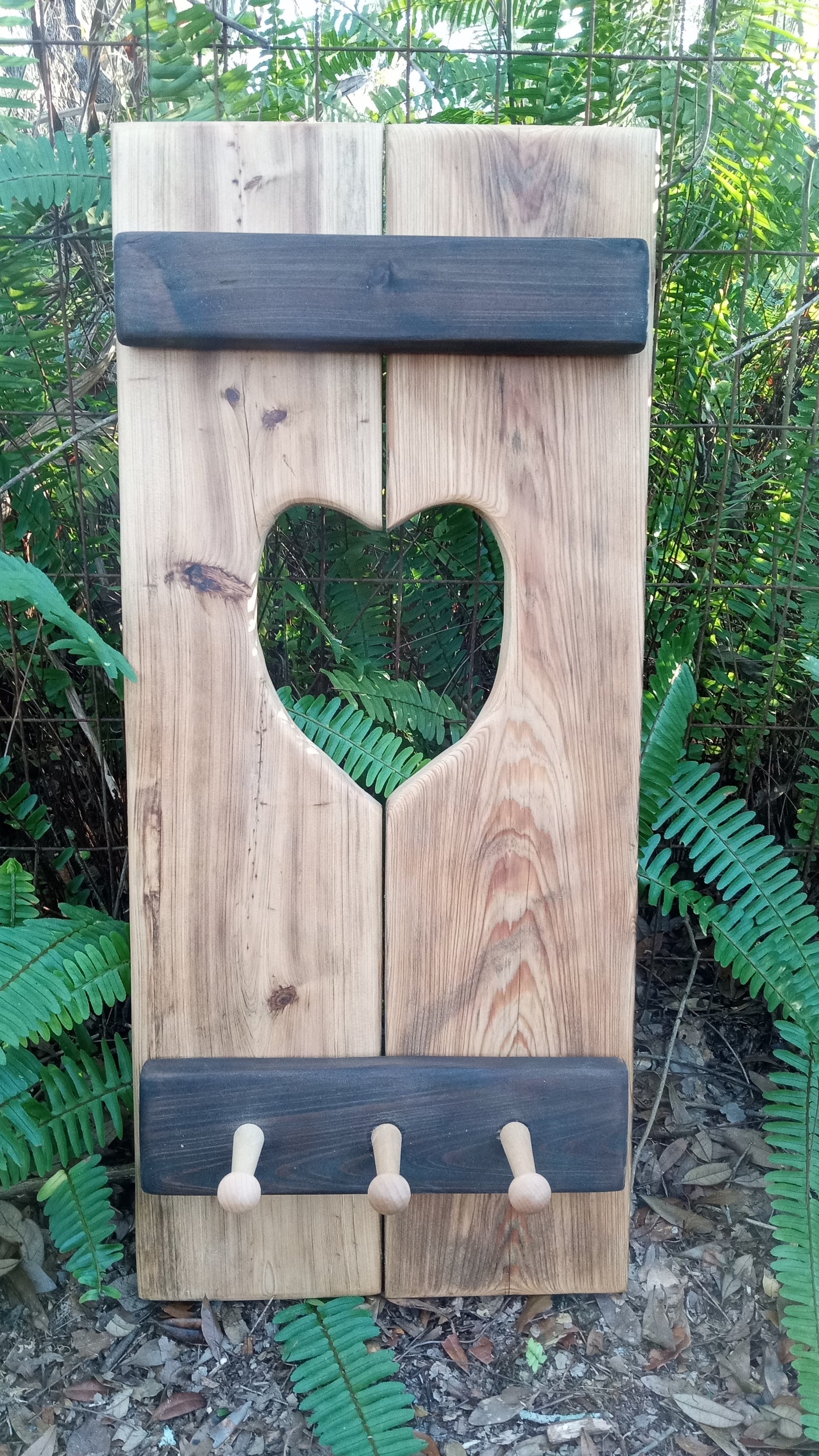 Cypress Wall Decor Coat Rack with heart-shaped cutout, three wooden pegs for hanging, crafted from rustic vertical planks for a cozy, durable touch.