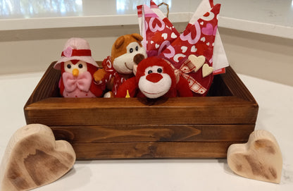 Large Cedar Planter Box on a white surface, holding three Valentine-themed plush toys and heart-patterned gift wrap, with two carved wooden hearts in front.