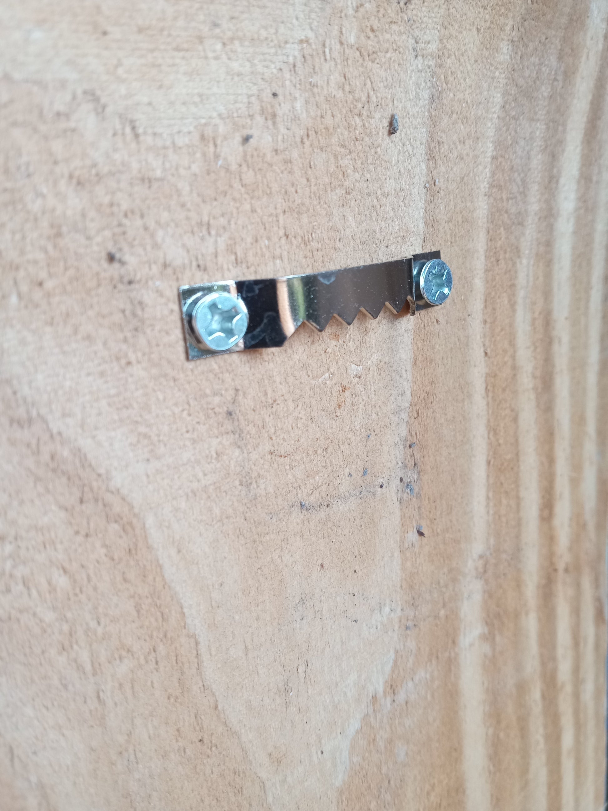 Hardware detail: sturdy silver metal hook designed to support hanging wall sconces.