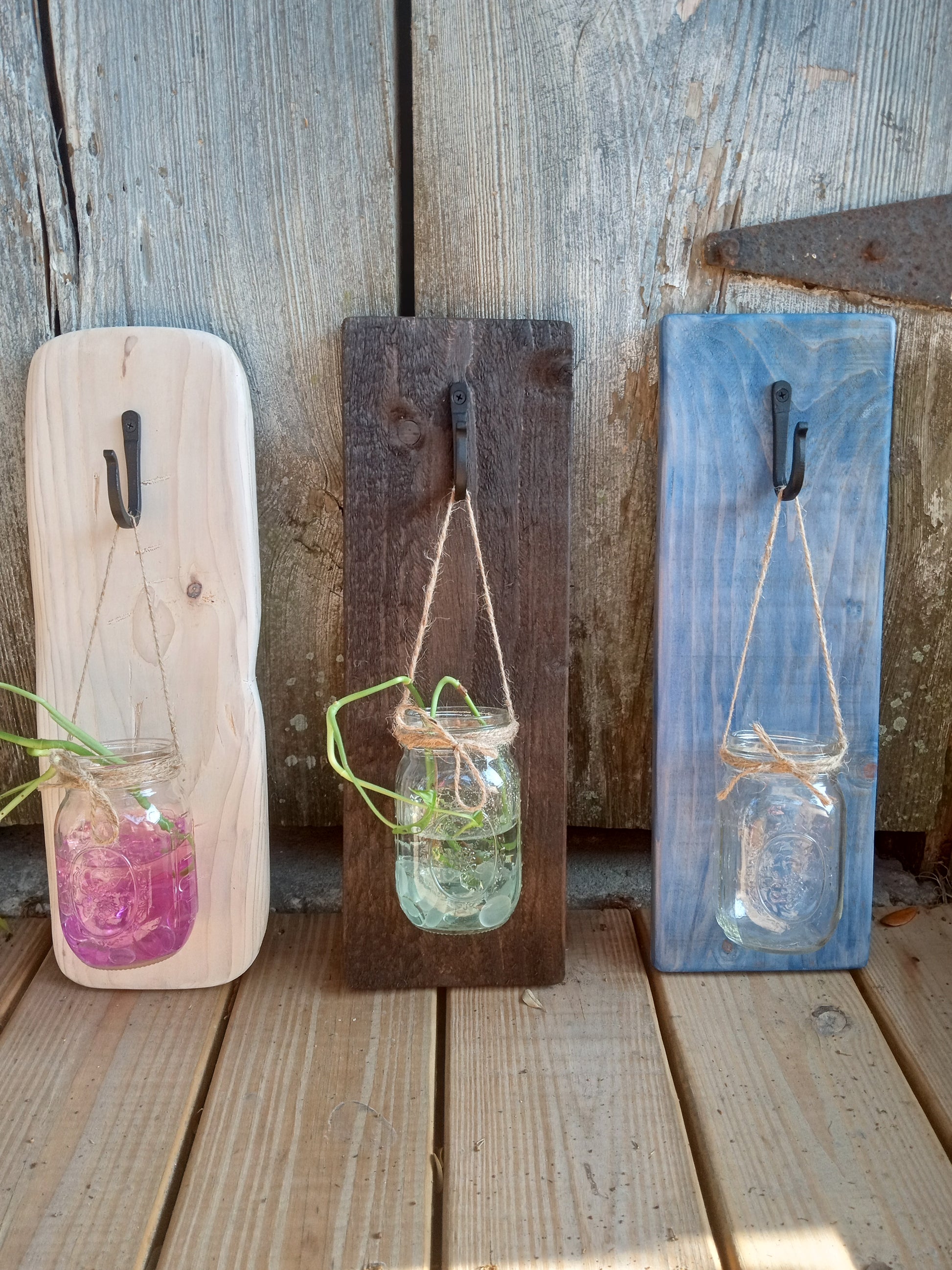 Three decorative mason jar wall sconces beautifully lined up to show variations in options.