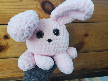 Pink plush toy bunny on a wooden surface