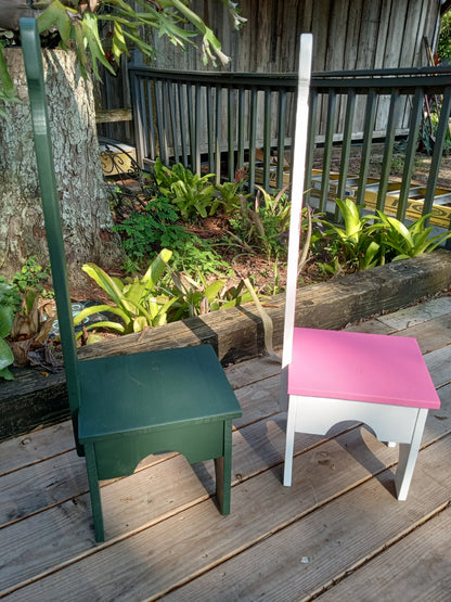Colorful Stable step stools standing sideways on a wooden deck with plants in the background.