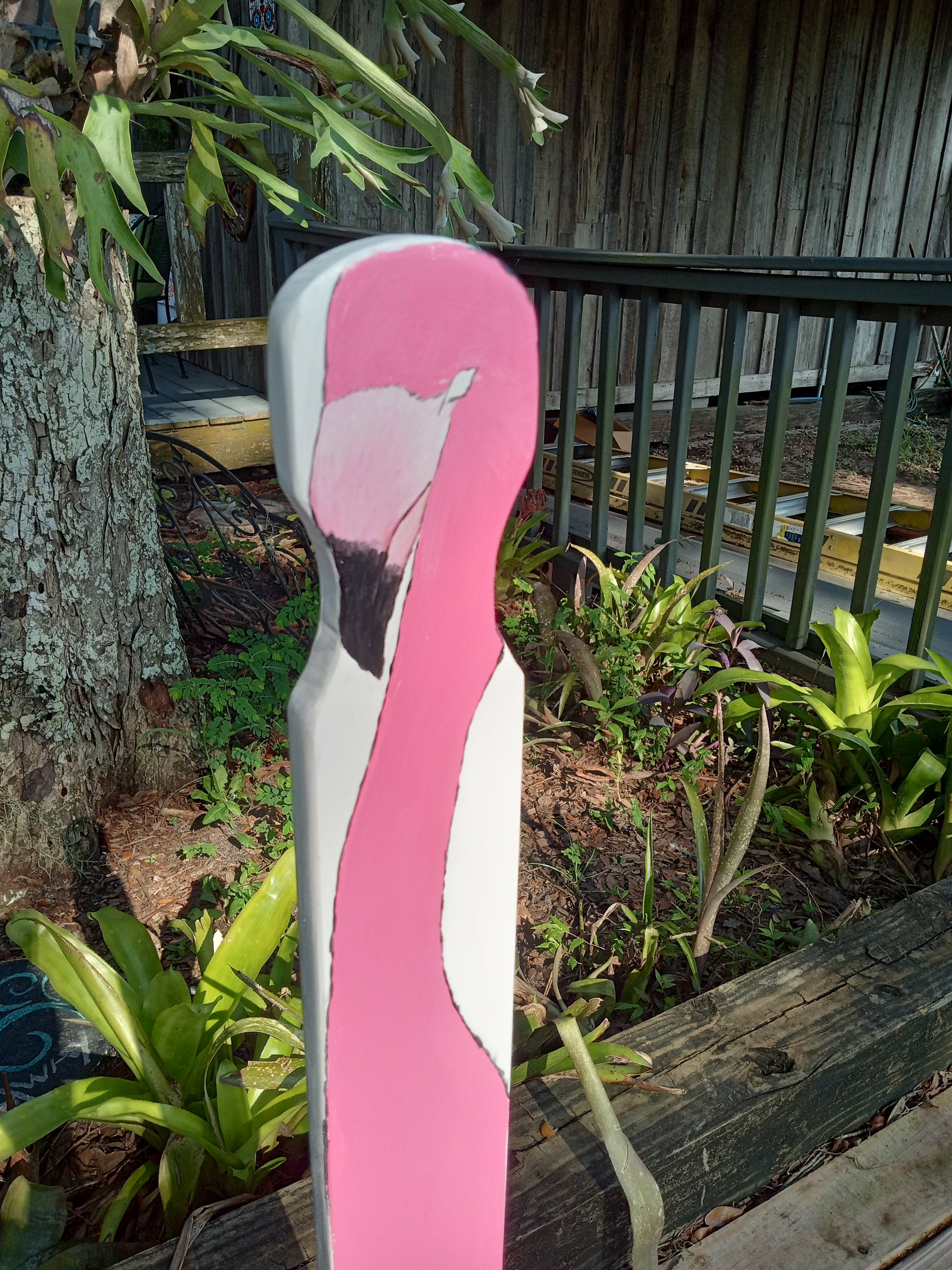 A close-up picture of the handle that is attached to the Sturdy step stool with a garden in the background.