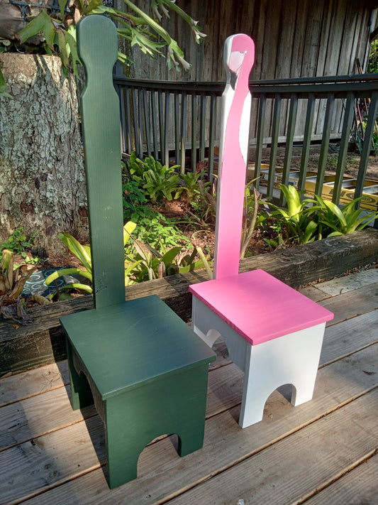 Two step stools standing side by side in an outdoor setting with two different color schemes on them.
