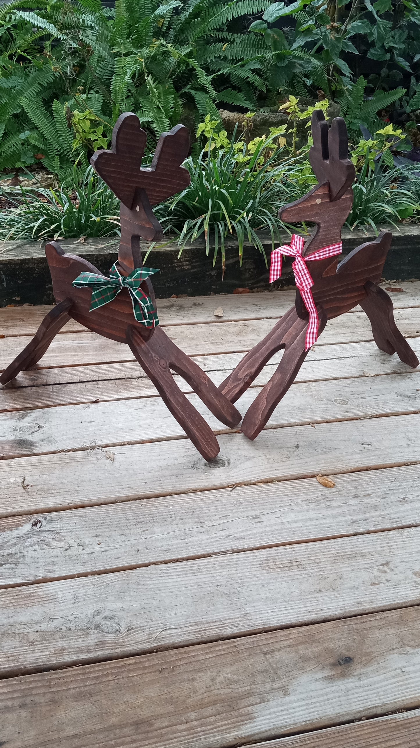 Wooden reindeer one with a  green bow and one with a red bow