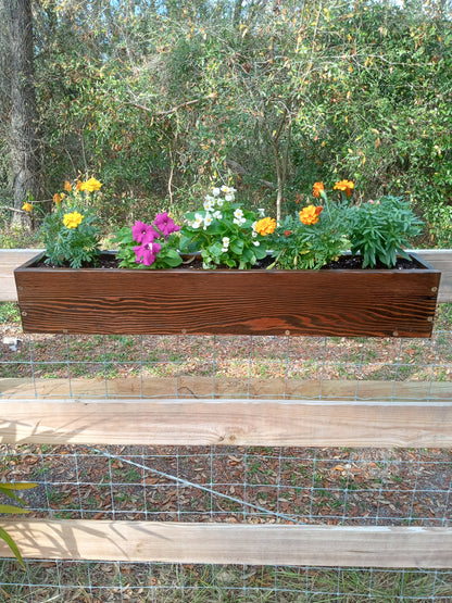 Hanging Fence Planters showcase durable stained-wood design, featuring vibrant flowering annuals, enhancing any fence with a pop of color for Spring gardening.